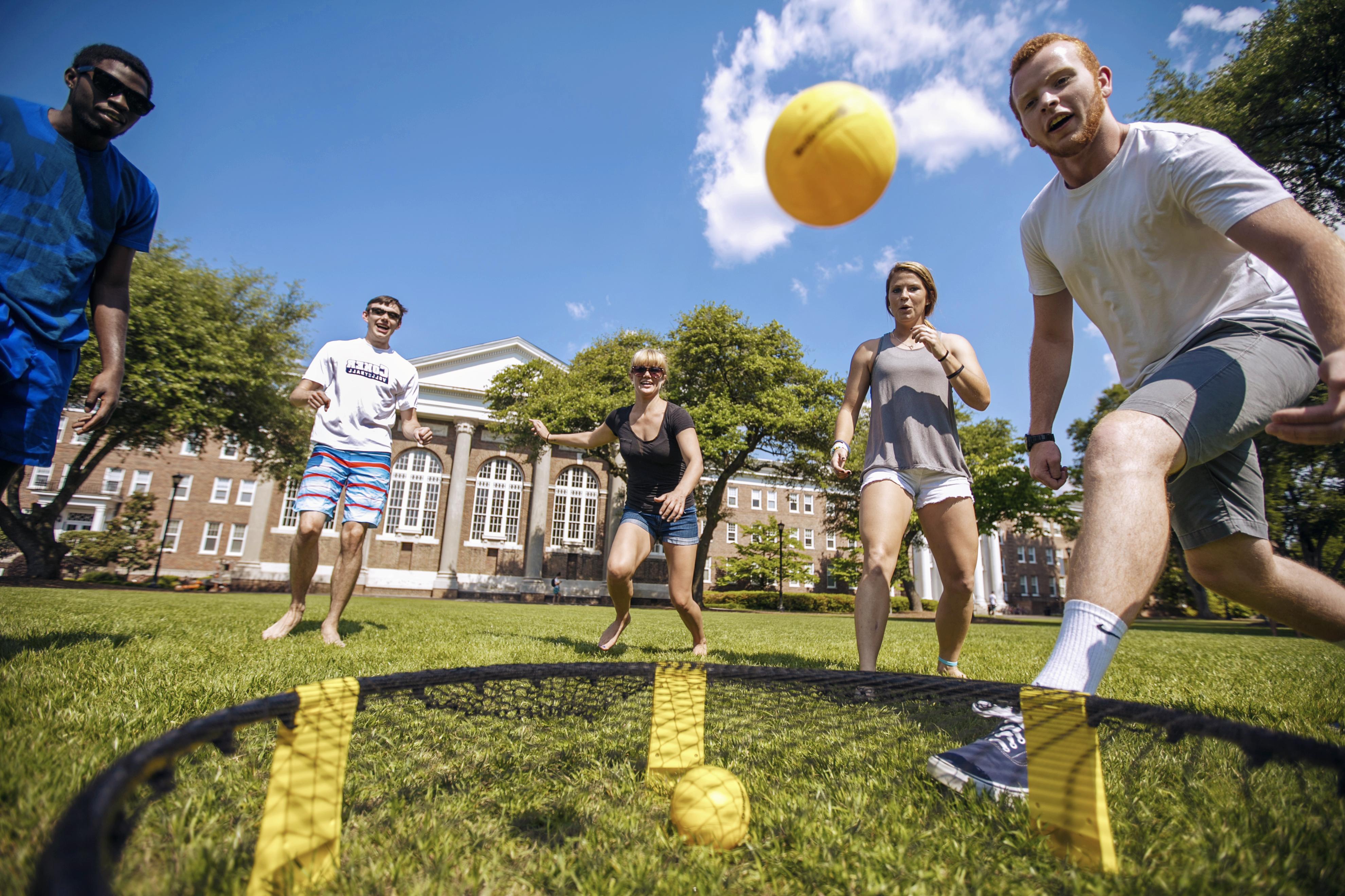 Students kick a ball around on the Davidson Hall lawn on a sunny afternoon